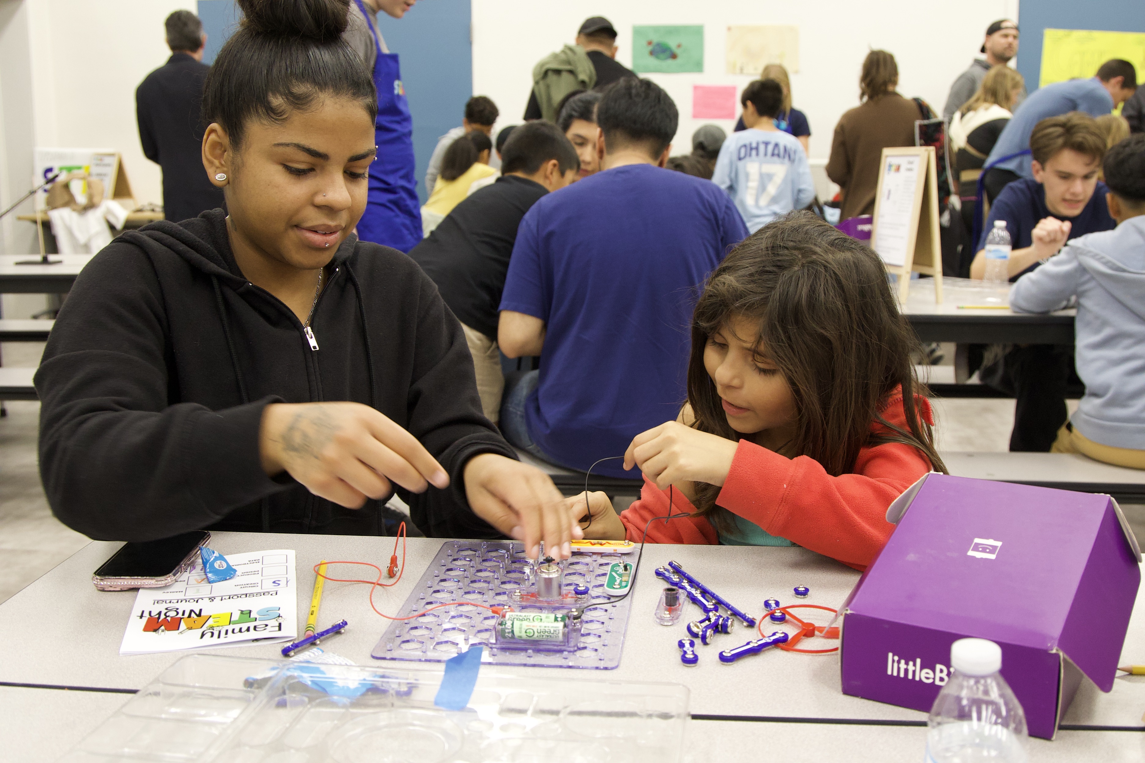 A parent helping their child with their kit at the Oceano Family STEAM Night