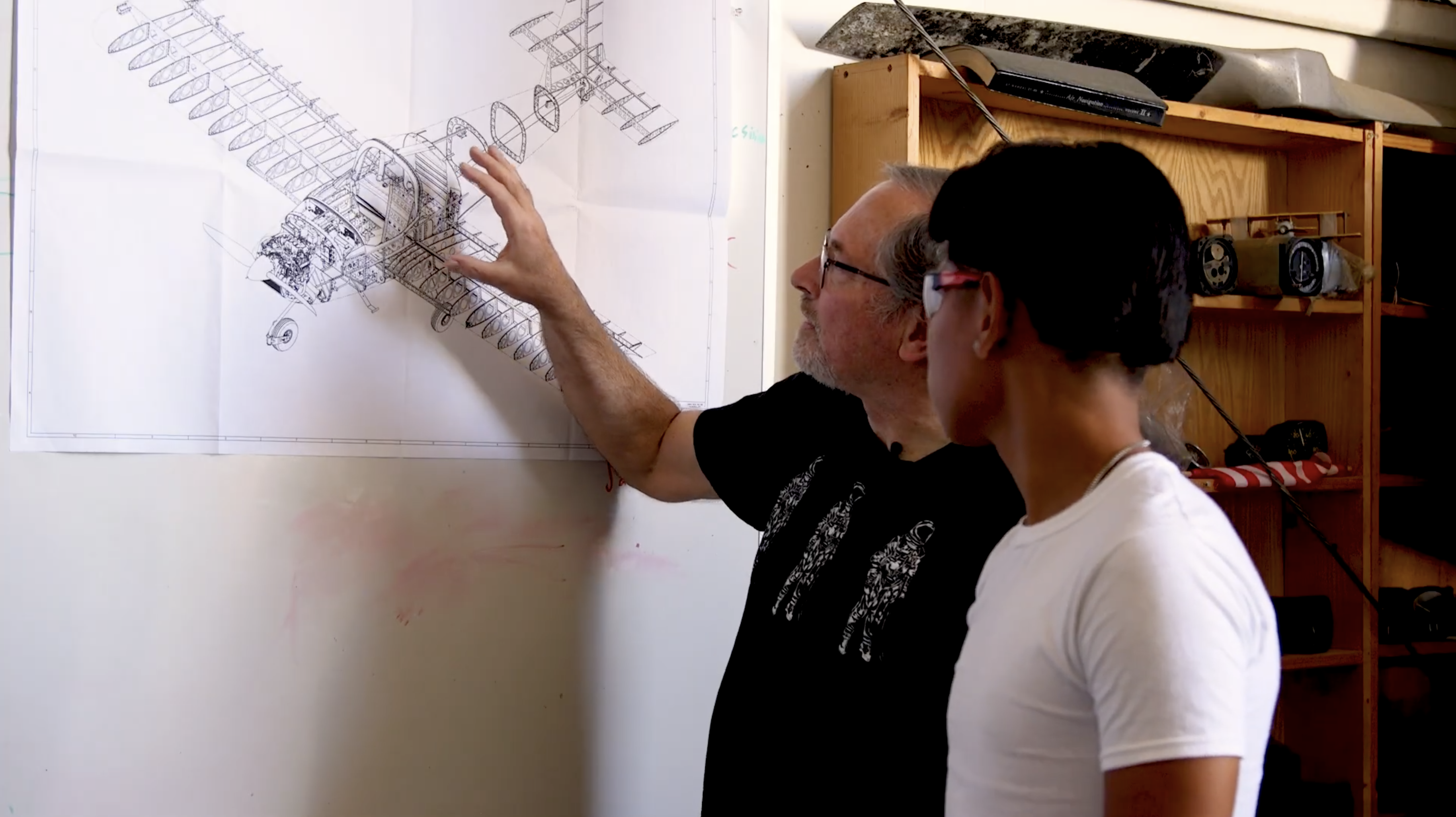 A Pajaro Valley student review airplane assembly plans with an adult volunteer.